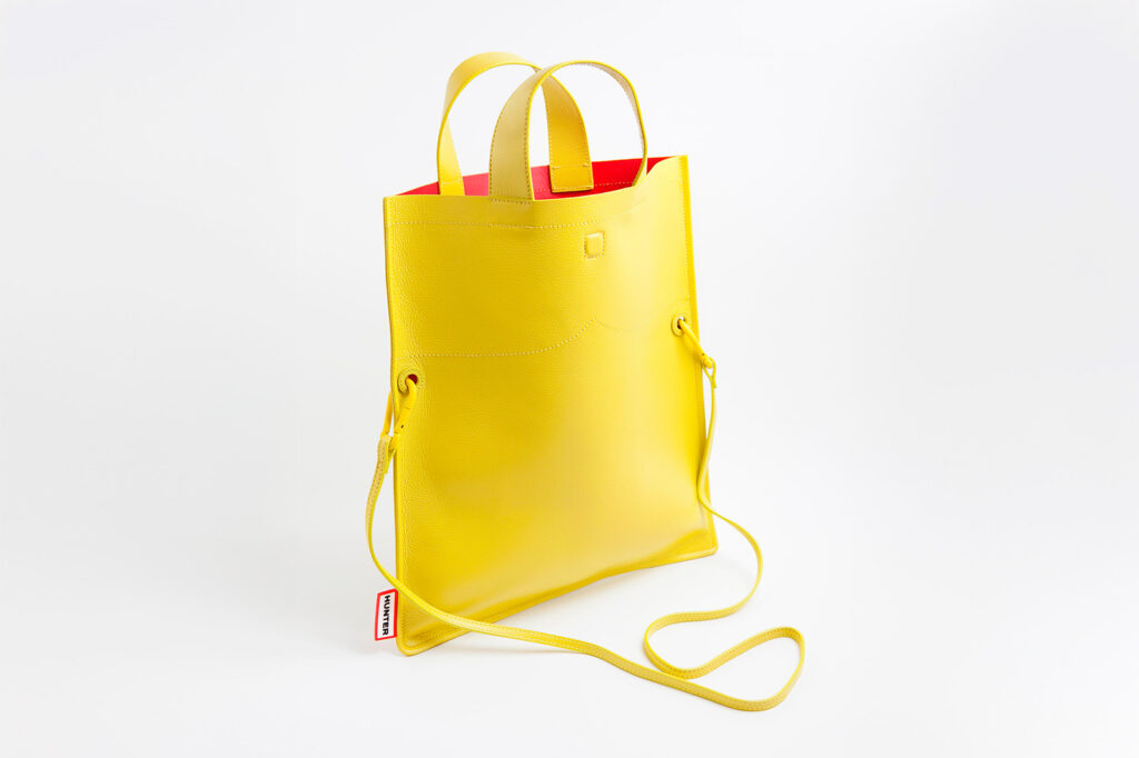 Fotografía lateral de bolso amarillo en fondo neutro
