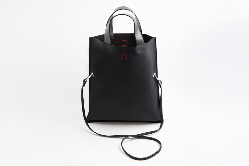 Fotografía de bolso negro minimalista sobre fondo blanco