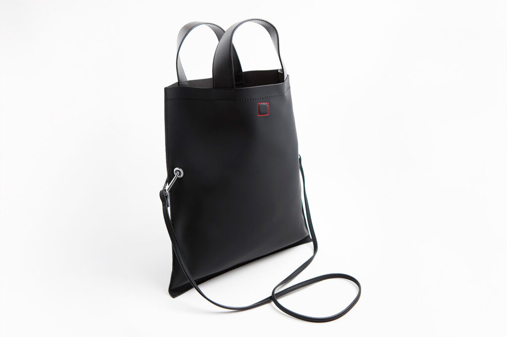 Fotografía lateral de bolso negro con diseño sencillo